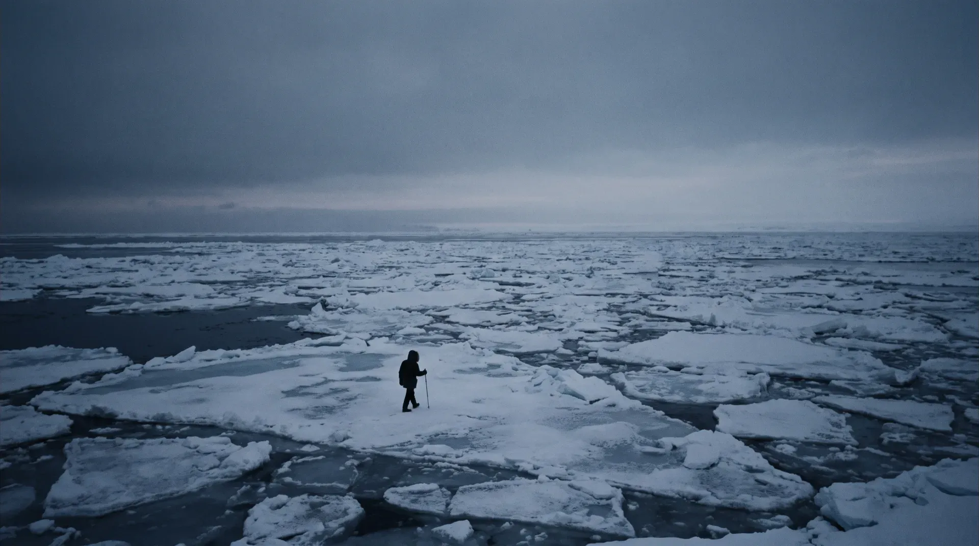 A vast frozen sea under a deep grey winter sky, broken ice sheets stretching to the horizon, a tiny lone figure walking across the ice