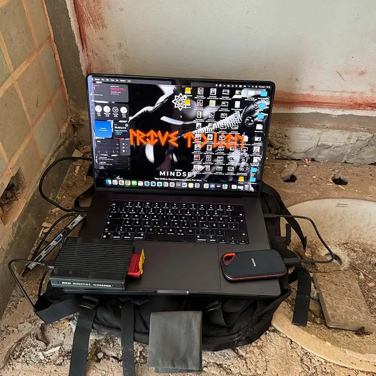 Data transfer on a MacBook on the “Last Inferno” set in a jungle house